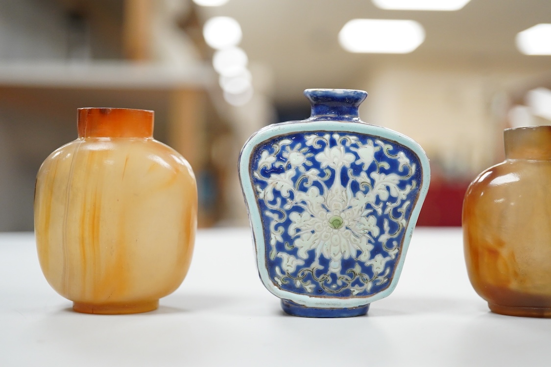 Three 19th century Chinese agate snuff bottles and a porcelain snuff bottle, largest 6cm high (4)